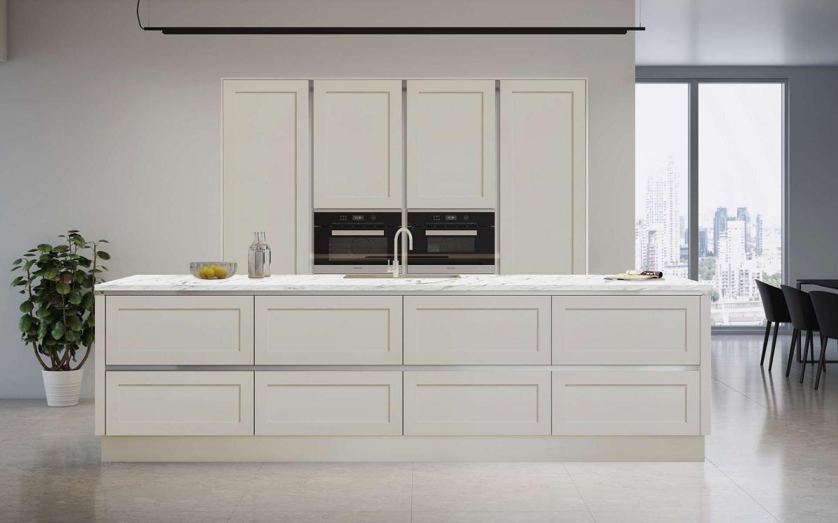 Open plan kitchen with island, white grey veined quartz worktops, recessed tall units in True Handleless Shaker Door Details Pebble style.