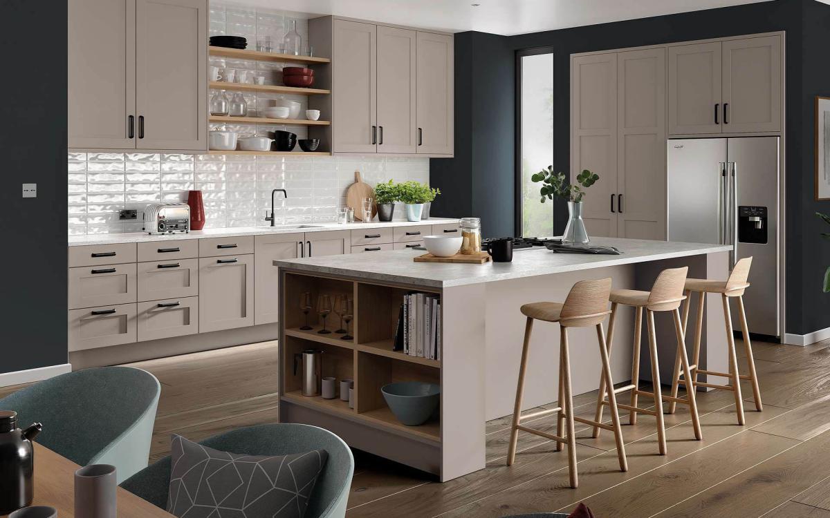 Modern clean kitchen with island, breakfast bar stools, and American-style fridge in Tenby Taupe style