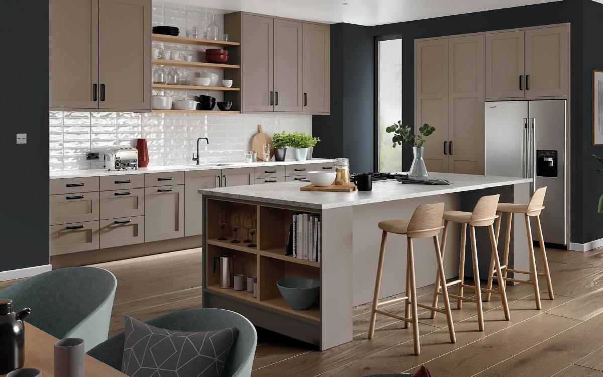 Modern clean kitchen with island, breakfast bar stools, and American-style fridge in Tenby Stone Grey style