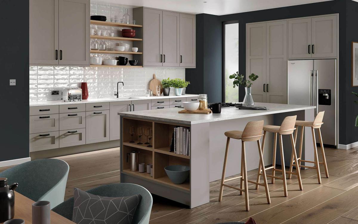 Modern clean kitchen with island, breakfast bar stools, and American-style fridge in Tenby Pebble style