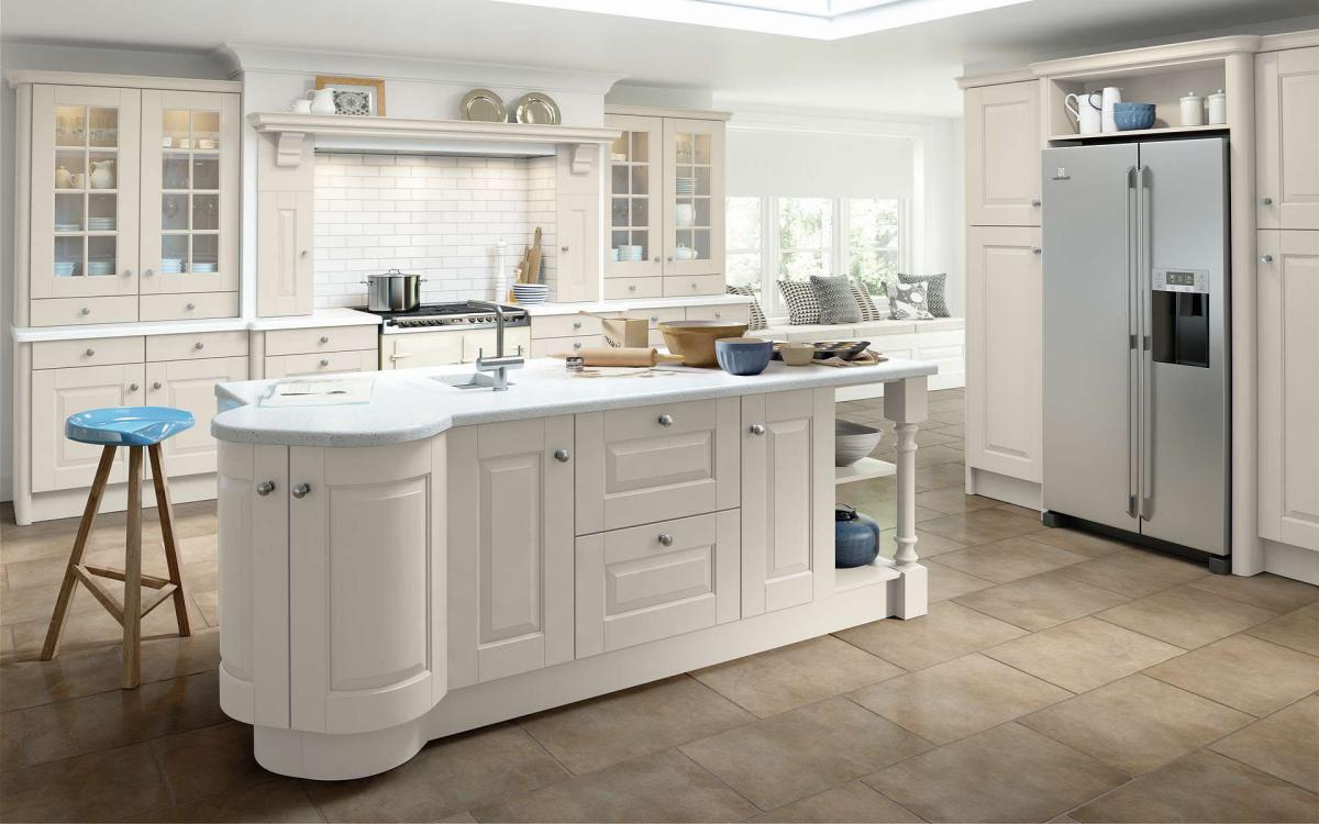 Open plan country kitchen with built-in American fridge, curved island feature, and glass door dresser units in Fleetwood Taupe style