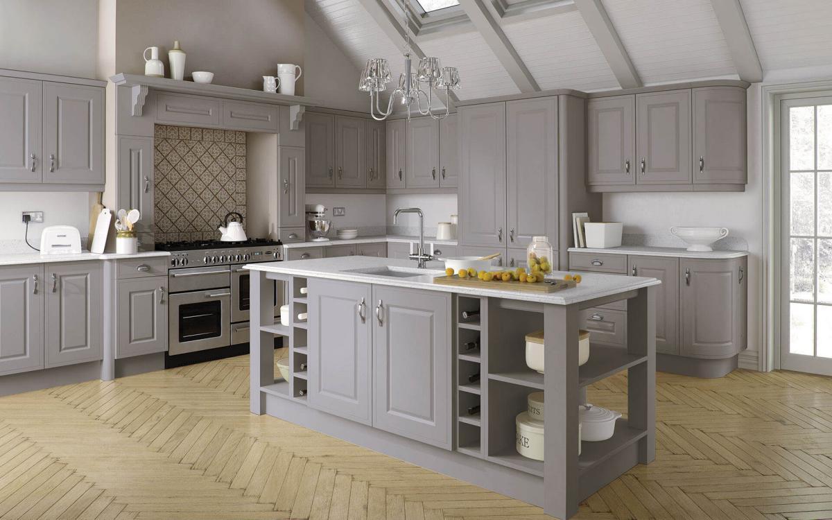 Large country kitchen with vaulted ceiling, chunky posts on island corners, and large overmantle feature in Helmsley Pebble style