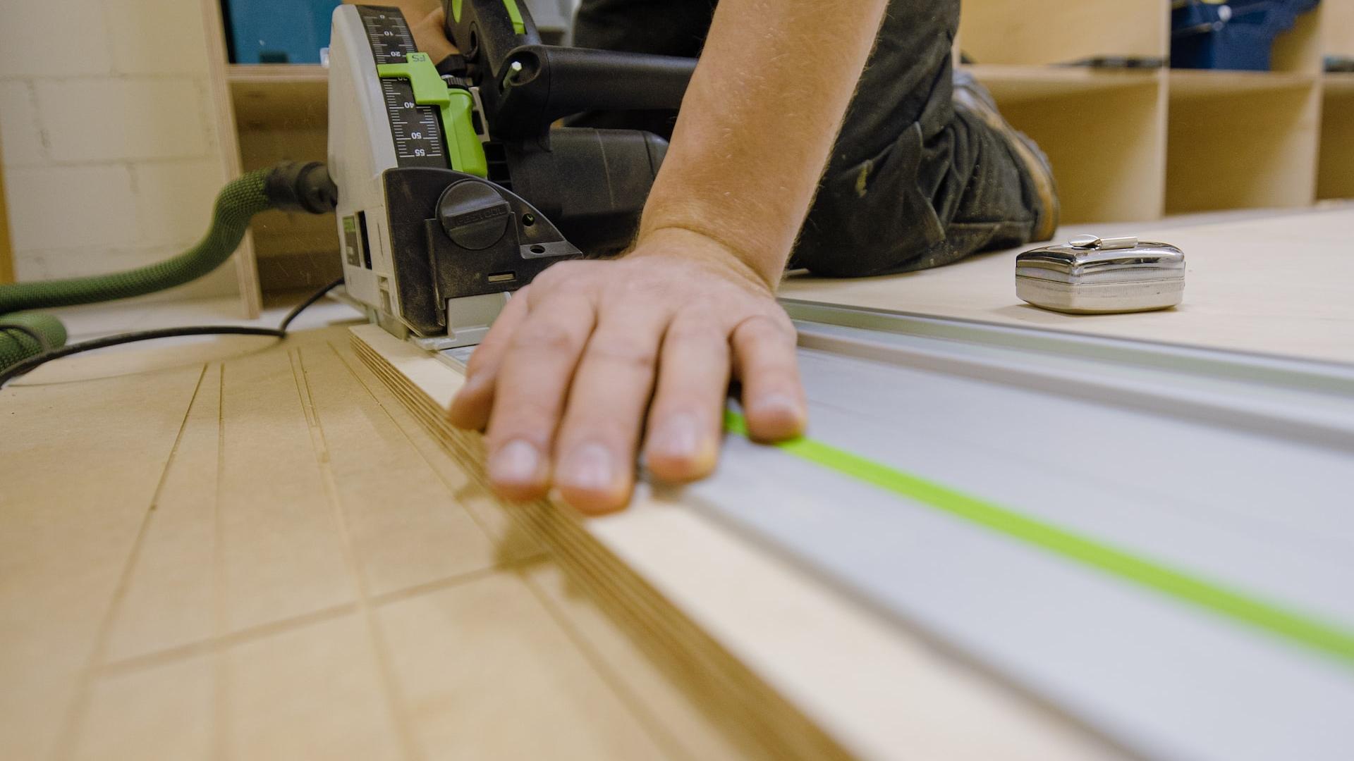 person in gray t-shirt holding green and white plastic tool
