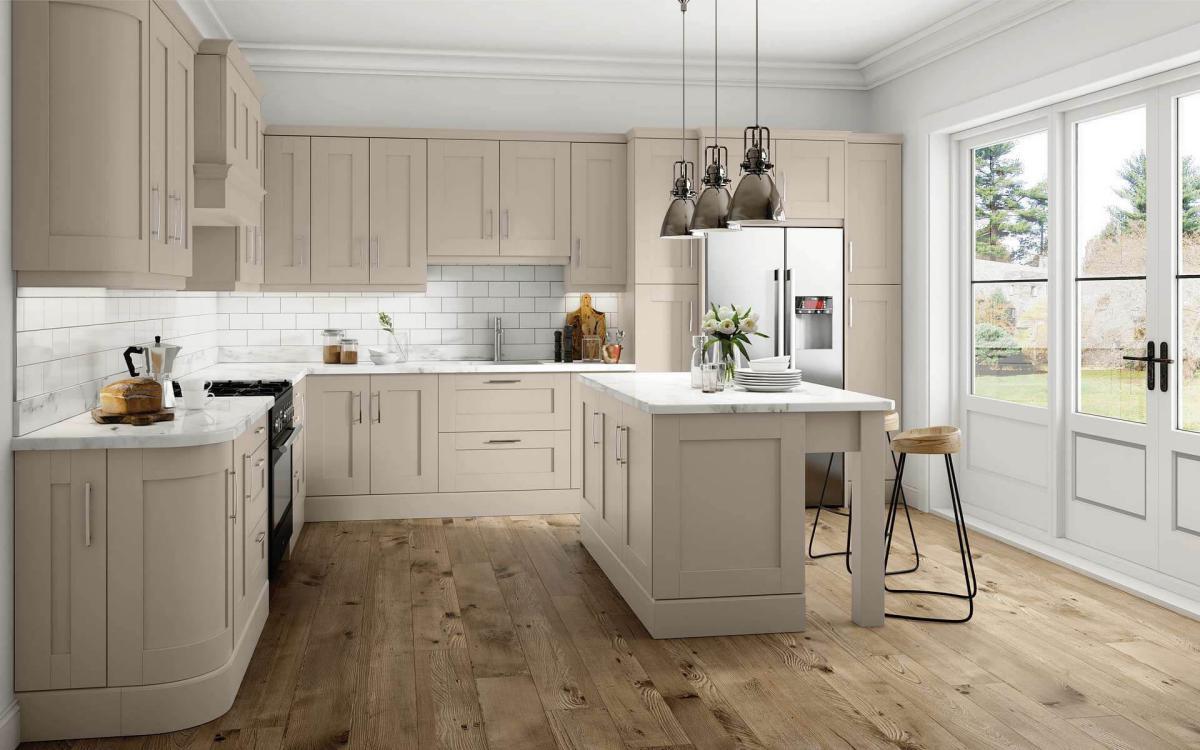 Kitchen with chunky leg posts island, American fridge, and black range oven in Elsworthy Stone Grey style