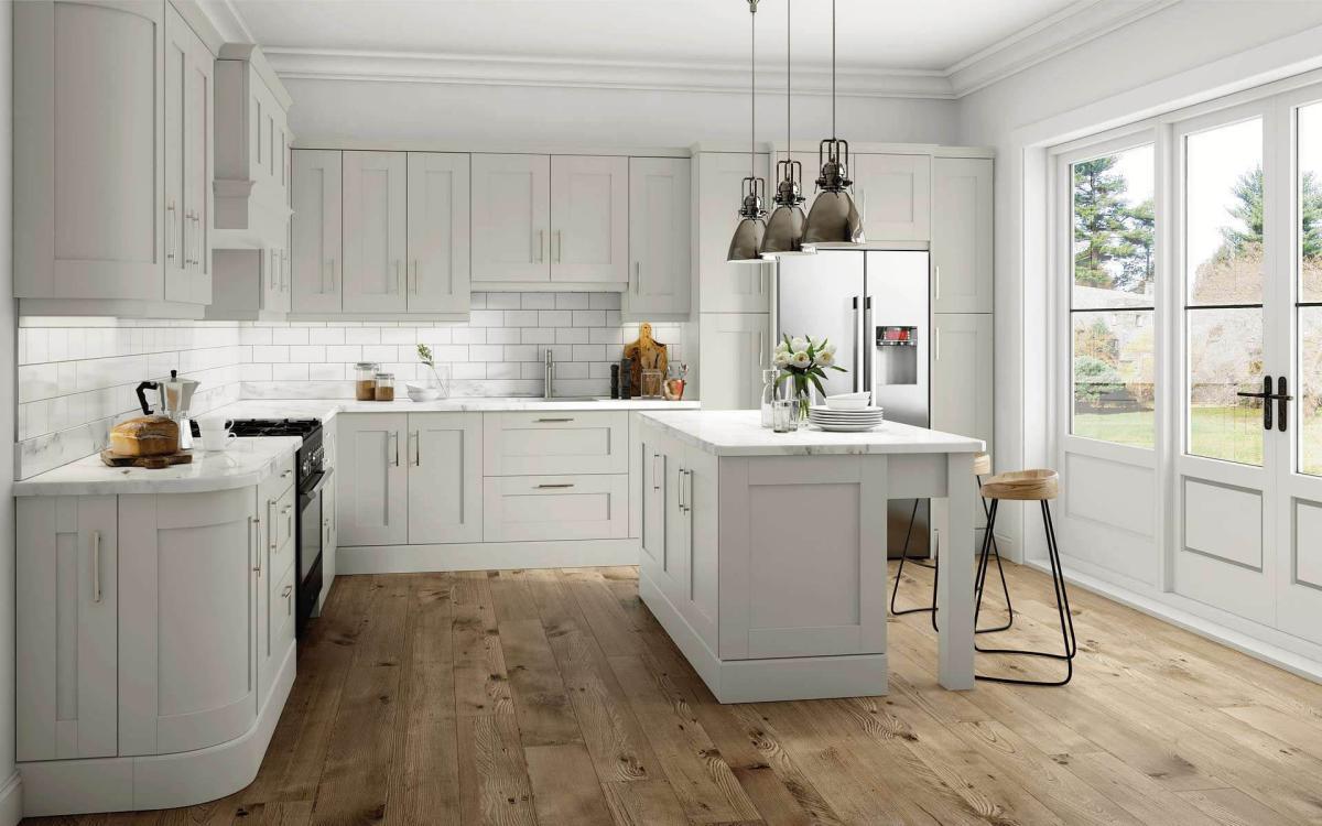 Kitchen with chunky leg posts island, American fridge, and black range oven in Elsworthy Pebble style