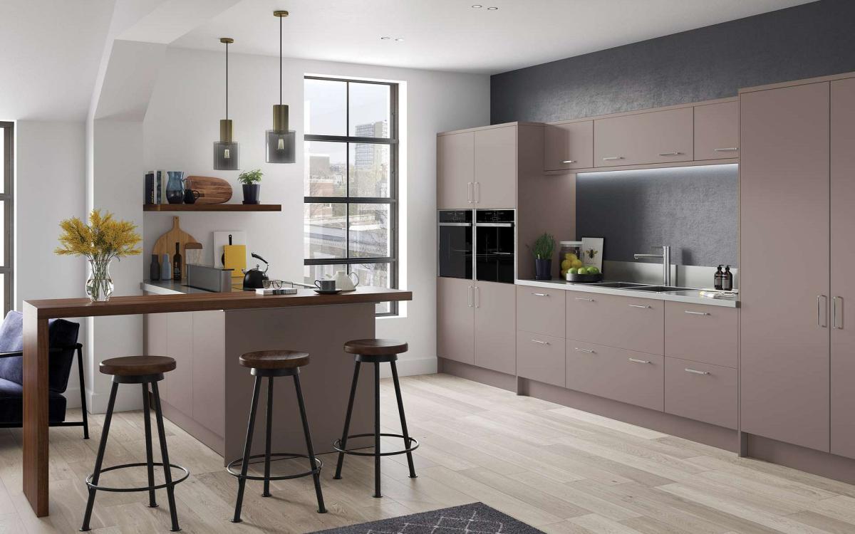 Simple slab door style kitchen with drawer units, peninsular feature, and walnut breakfast bar in Artino Stone Grey style