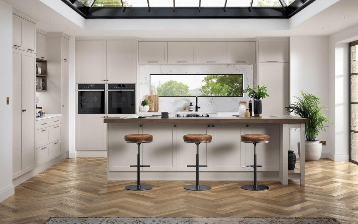 Open plan kitchen with large island, thick square edge wood worktop, and wide feature window in Hembury Taupe style